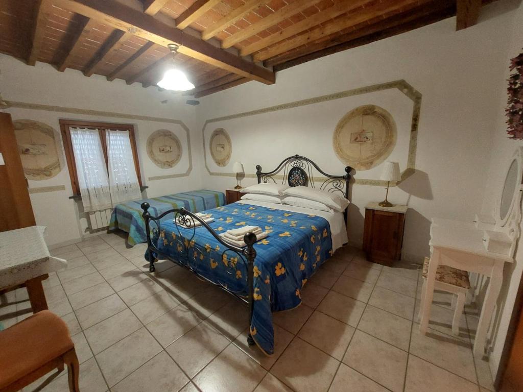 Schlafzimmer mit einem Bett mit blauer Decke in der Unterkunft La Convenienza in Cascina