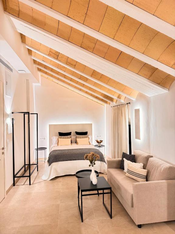 a living room with a bed and a couch at Casa Boutique Navarro in Montilla