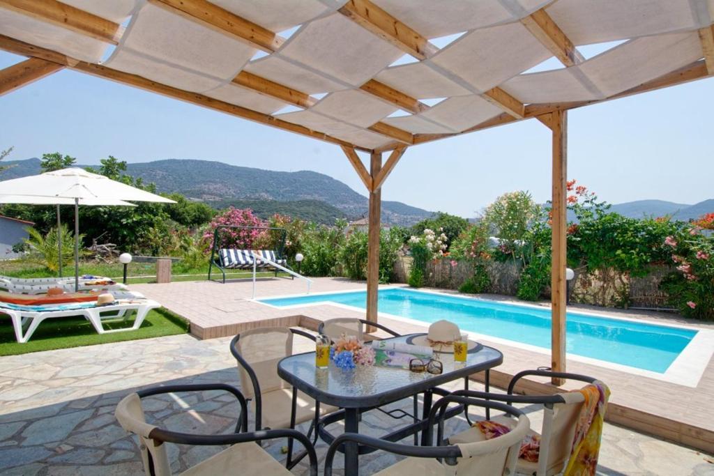 a patio with a table and chairs and a pool at Thalassa Home Comfort in Petra