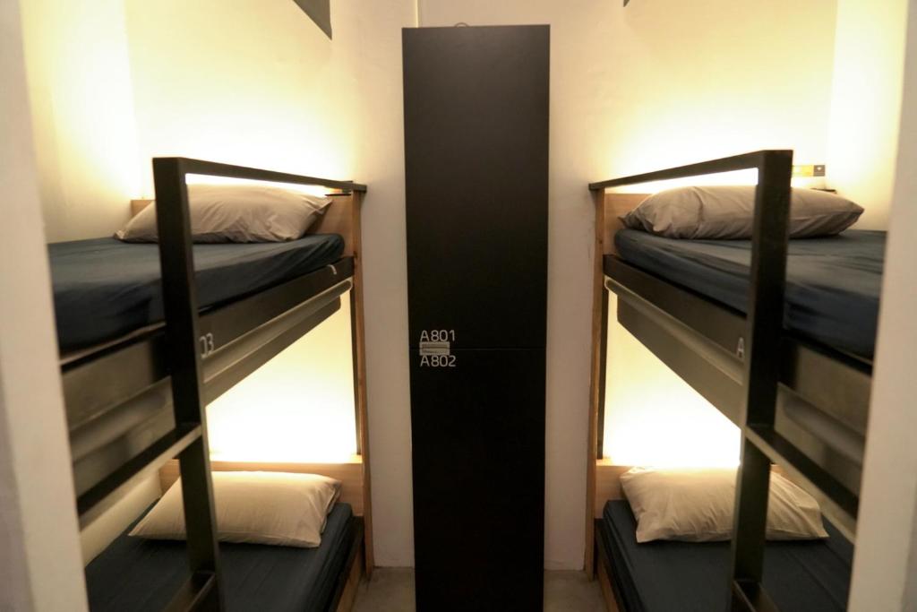 two bunk beds in a room with a mirror at Meeting Mates Hostel in Taipei
