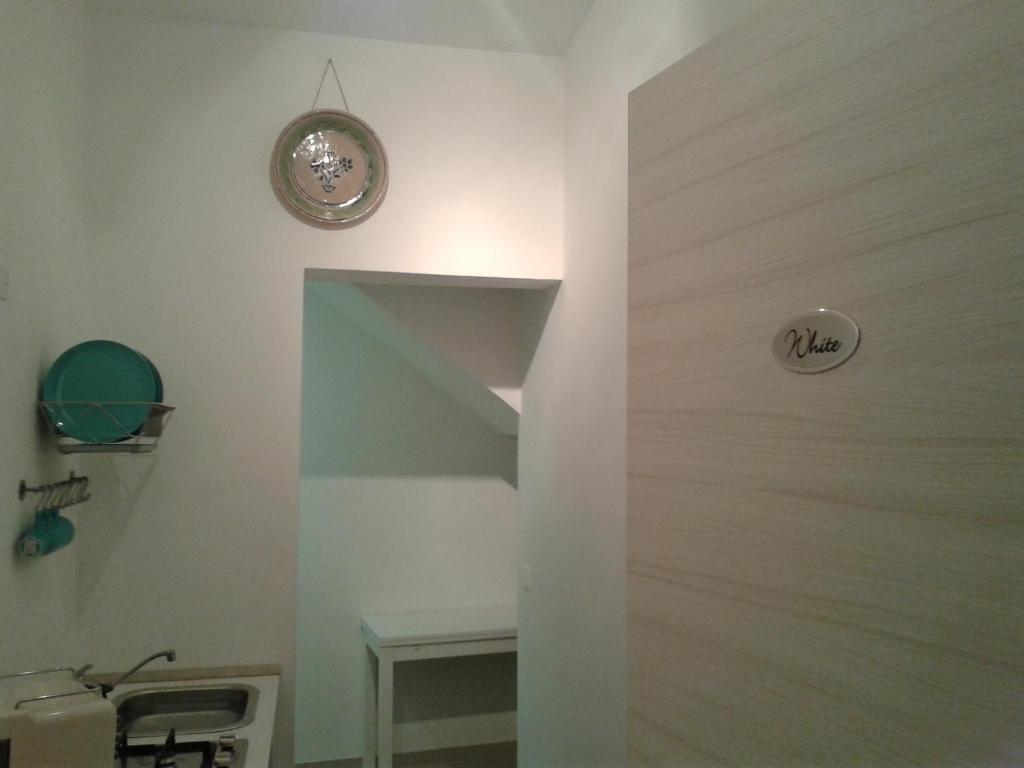 ein Badezimmer mit einer Treppe mit einer Uhr an der Wand in der Unterkunft Casa Andolina White in Noto