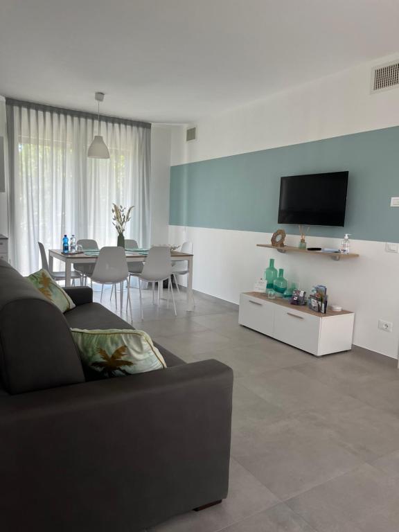 un soggiorno con divano e TV di "La Terrazza di Via Roma" Delta del Po - Private Parking a Porto Viro