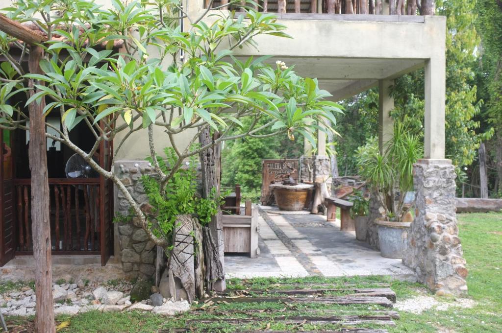 a garden with a group of trees and benches at Sepat Village House by the Beach in Kuantan