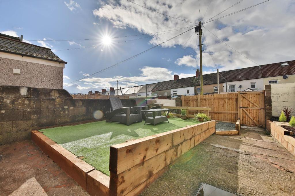a backyard with a green lawn and a fence at Beautiful 3 Bedroom Home Renovated Centrally Located in South Wales in Caerphilly