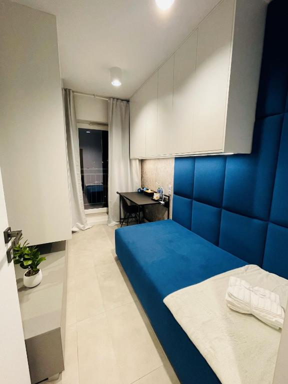 een slaapkamer met een blauw bed en een bureau bij Blue room in Żory