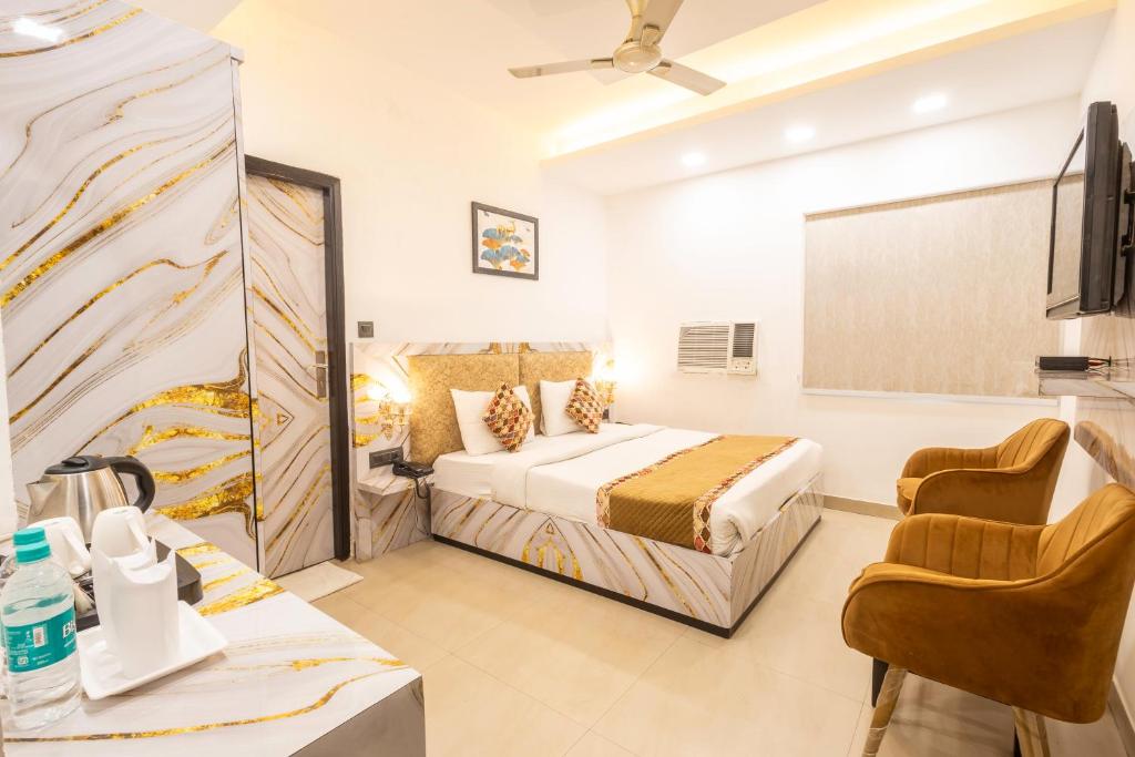 a hotel room with a bed and a tv at Hotel Cosmo Karol Bagh in New Delhi