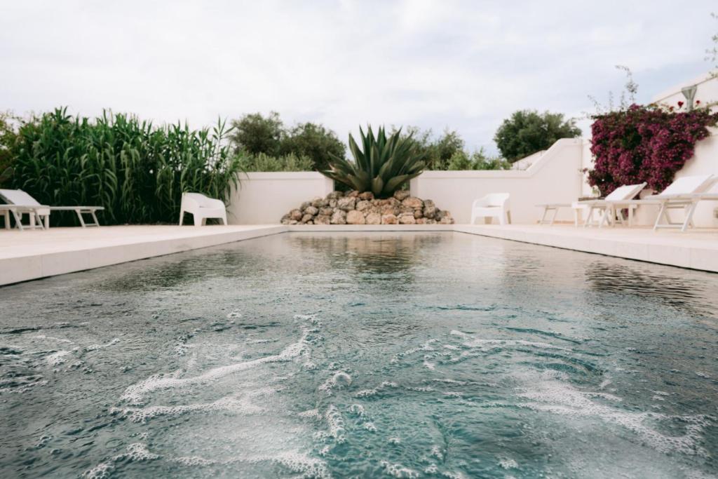 a swimming pool in a villa with white walls at Oltre gli Ulivi in Ostuni