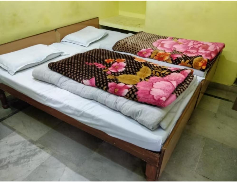 a bed with a blanket on it with flowers on it at Hotel Chandradeep, Joshimath in Joshīmath