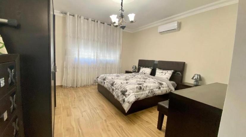 a bedroom with a bed and a dresser in it at Luxury Apartment 3BR near 7th circle in Amman