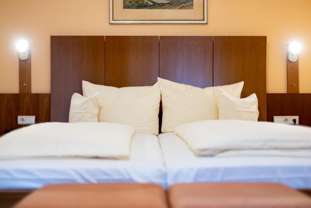 2 Betten in einem Hotelzimmer mit weißen Kissen in der Unterkunft Hotel Alter Kranen in Würzburg