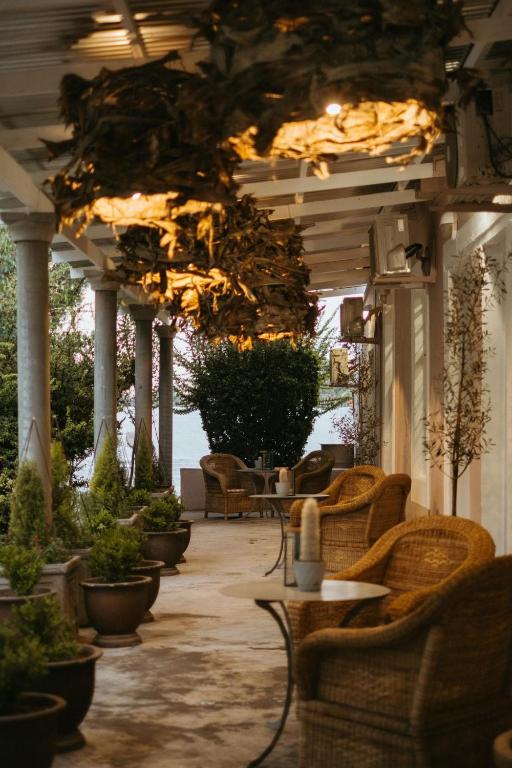 a patio with wicker chairs and tables and plants at The Hanover Luxury Hotel in Hanover