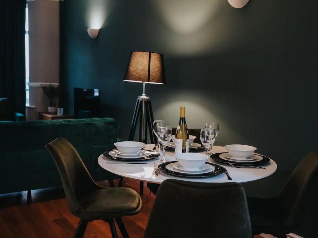 - une table avec une bouteille de vin et une table avec des chaises dans l'établissement Pass the Keys - Serene Green Retreat - 3 Bed Tuebrook Terrace, à Liverpool