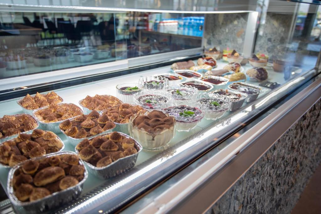 a display case filled with muffins and other desserts at Resort Zdrava in Savër