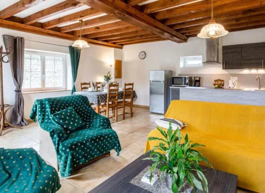 un salon avec un canapé et une cuisine dans l'établissement Gite LE CLOS RENARD, à Commes