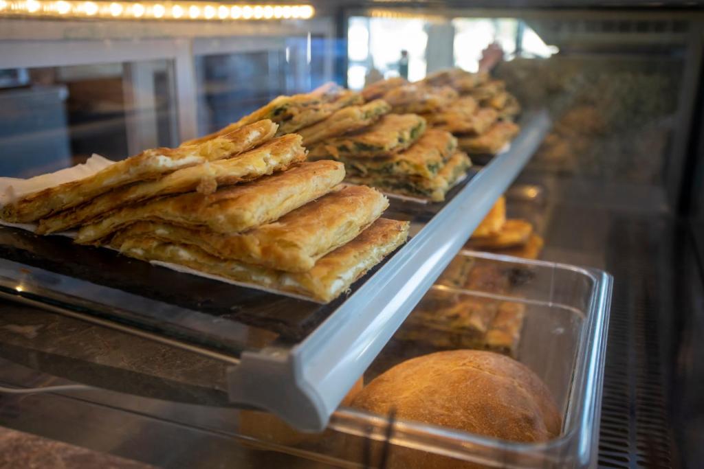 a display case in a bakery with pastries and bread at Resort Zdrava in Savër