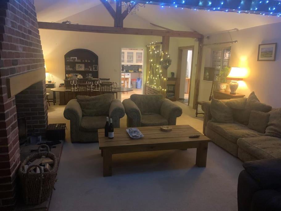 uma sala de estar com sofás e uma mesa de centro em Relaxing country cottage bungalow em Yaxley