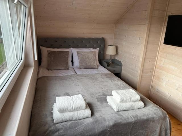 a bedroom with a large bed with two pillows at Silver Park in Gąski