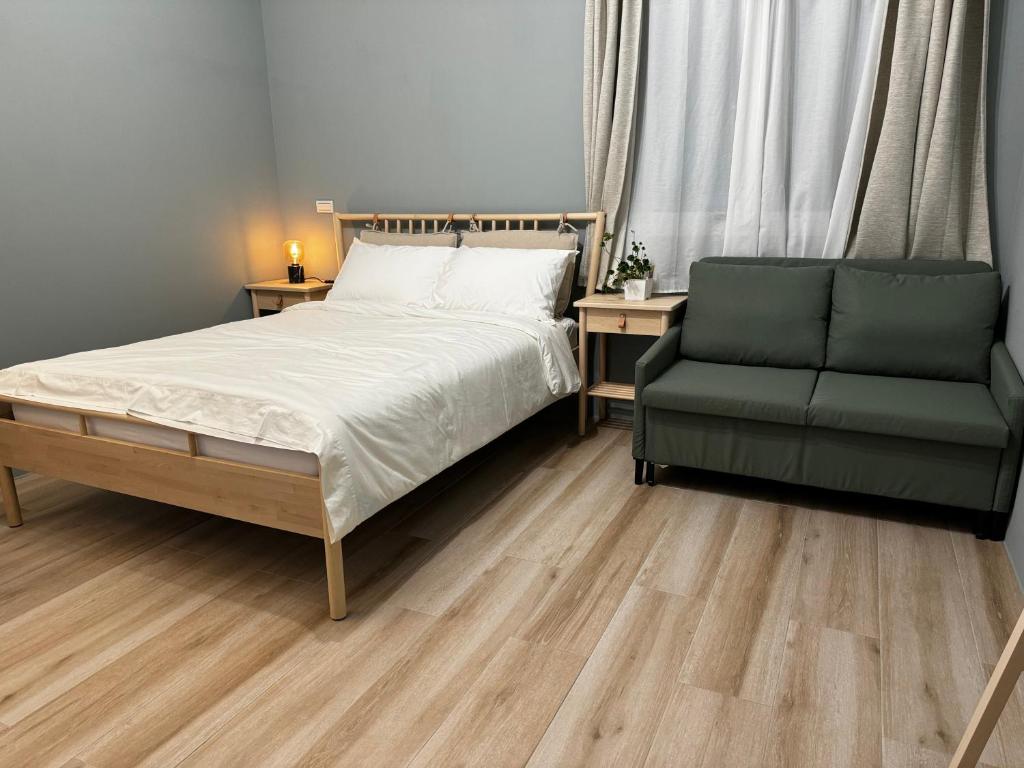1 dormitorio con 1 cama y 1 silla verde en 澄靛民宿, en Taitung