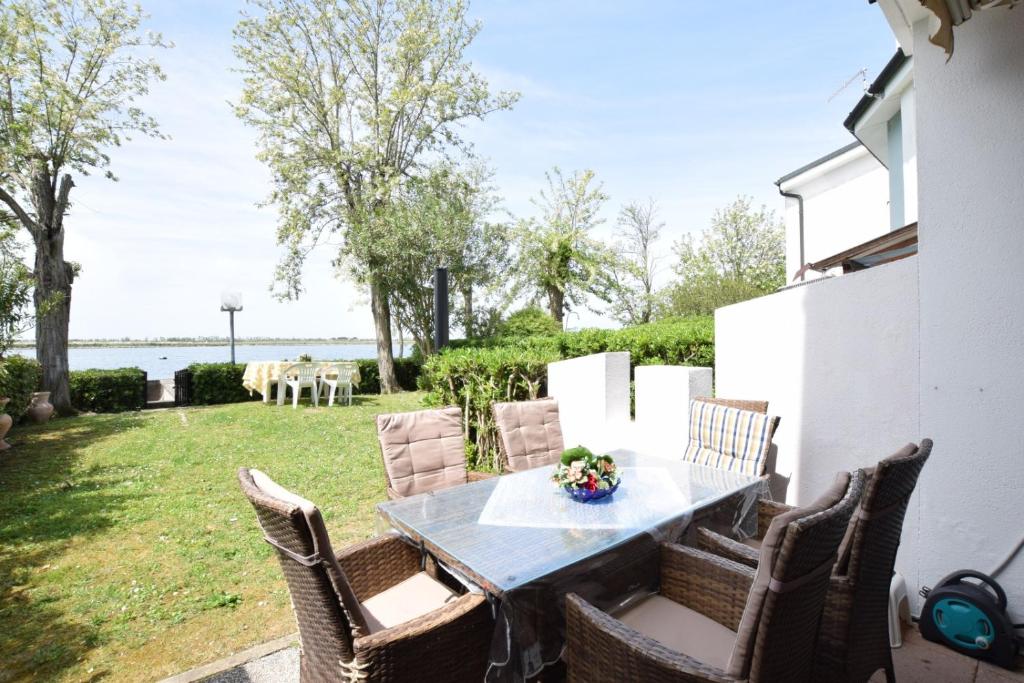 a table and chairs on a patio with a view of the water at Villa Fortuna in Palazzo Vianello