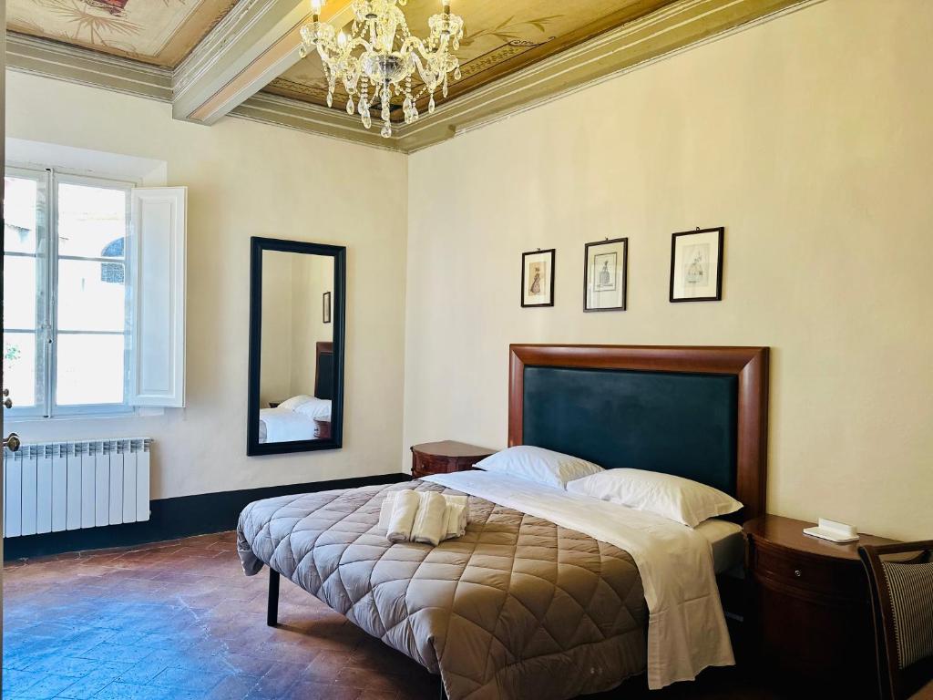 ein Schlafzimmer mit einem großen Bett und einem Kronleuchter in der Unterkunft Domus An- Two Bedrooms Apartment -Antique and Historical Home in Siena