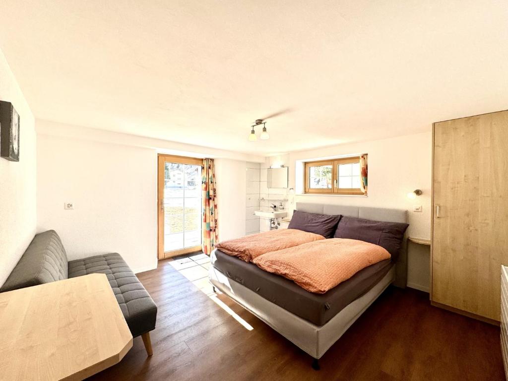a bedroom with a bed and a couch at Haus Chalet Arnika in Saas-Grund