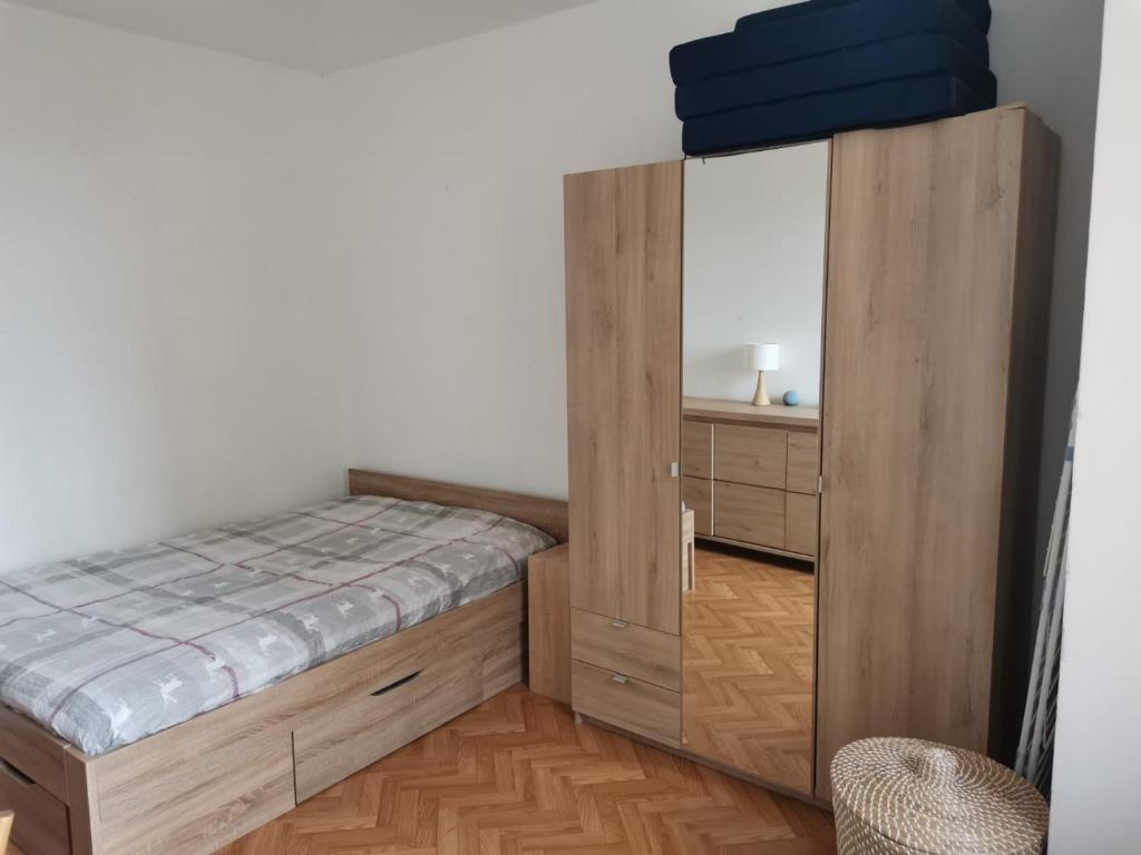 Schlafzimmer mit einem Bett und einem Holzschrank in der Unterkunft Charmant Appartement 3 chambres - JO Paris 2024 in Colombes