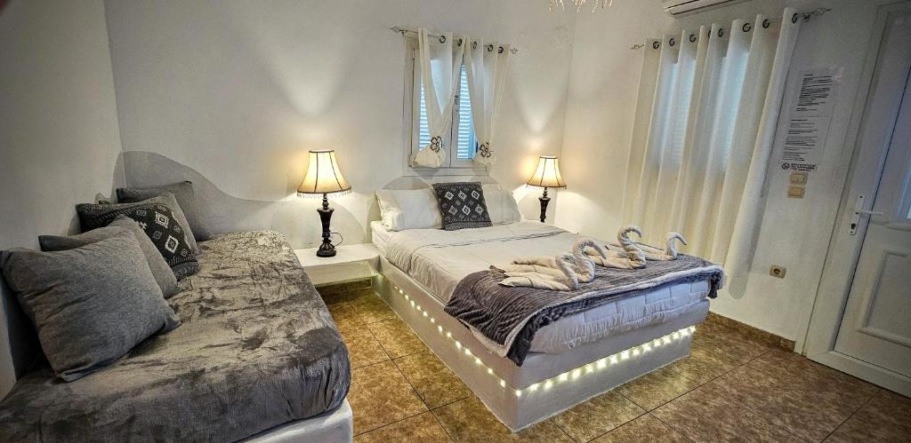 1 dormitorio con 2 camas y 2 lámparas. en Pleasure Seaside Rooms en Perissa
