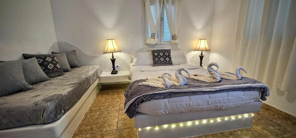 a room with a bed with swans on it at Pleasure Seaside Rooms in Perissa