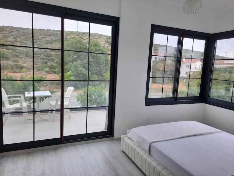 una camera con letto e ampie vetrate di Çeşme merkezde özel havuzlu villa, a Ildir