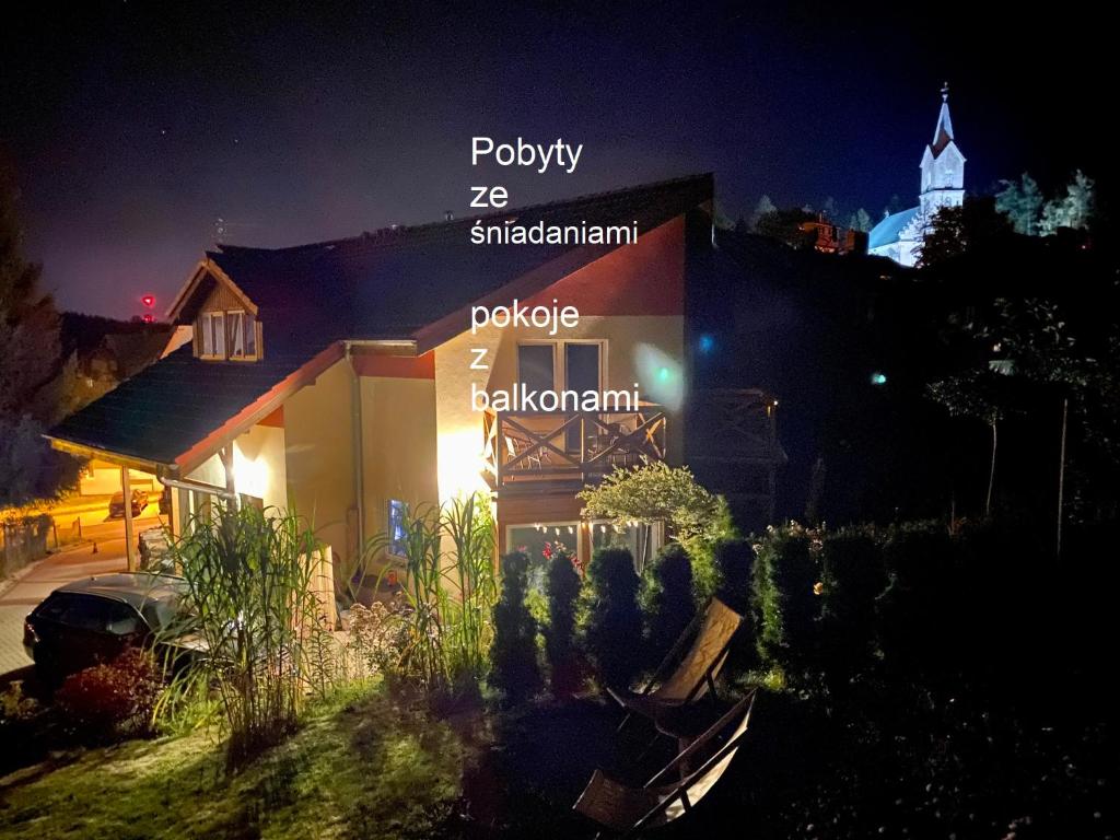 a building with words on it at night at DOMINO - pokoje i apartamenty in Szklarska Poręba