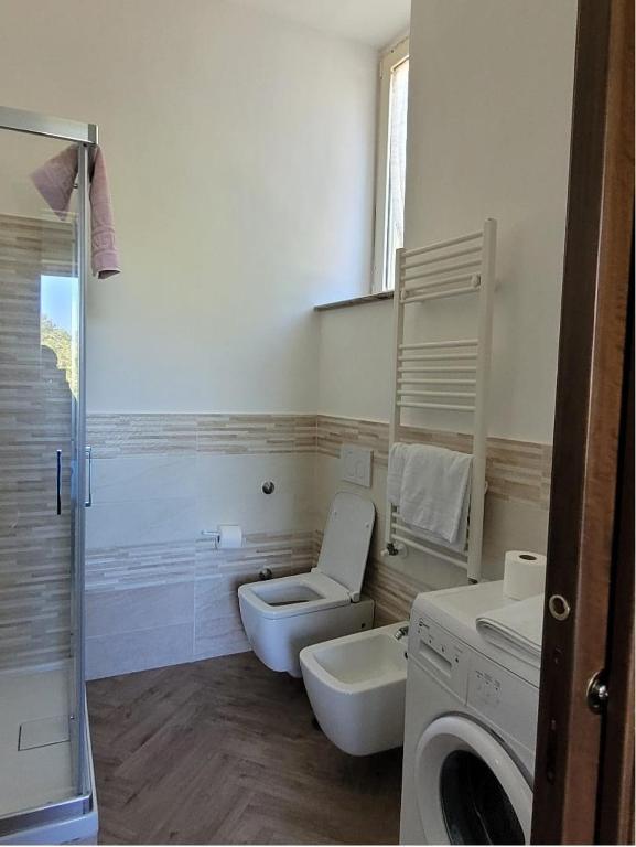 a bathroom with a toilet and a sink and a washing machine at Luna D'Agerola in Agerola