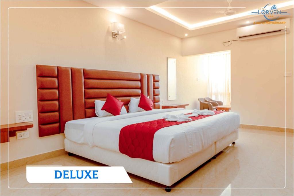 a bedroom with a large bed with red pillows at Hotel Lorven in Tirupati