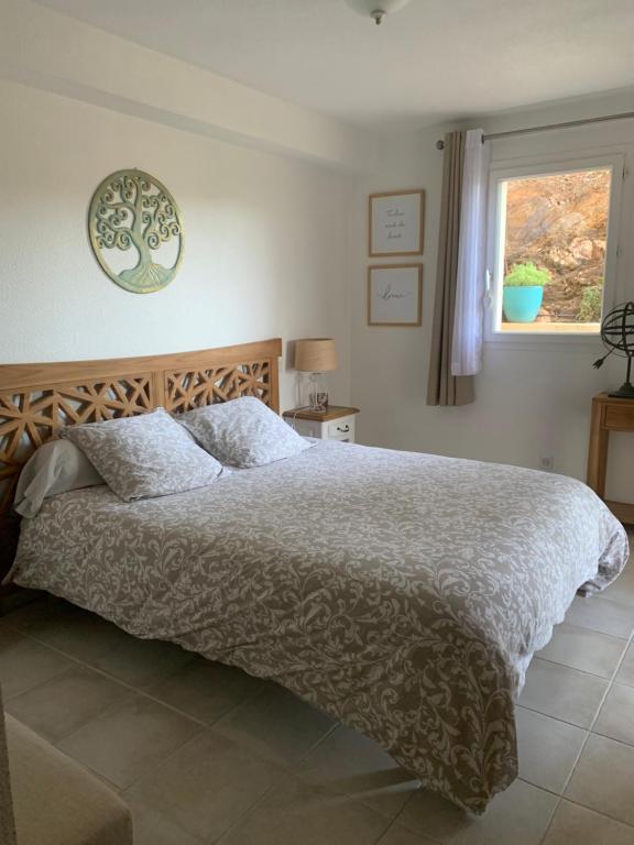 ein Schlafzimmer mit einem großen Bett und einem Fenster in der Unterkunft Chambre 2 dans un petit paradis in La Londe-les-Maures