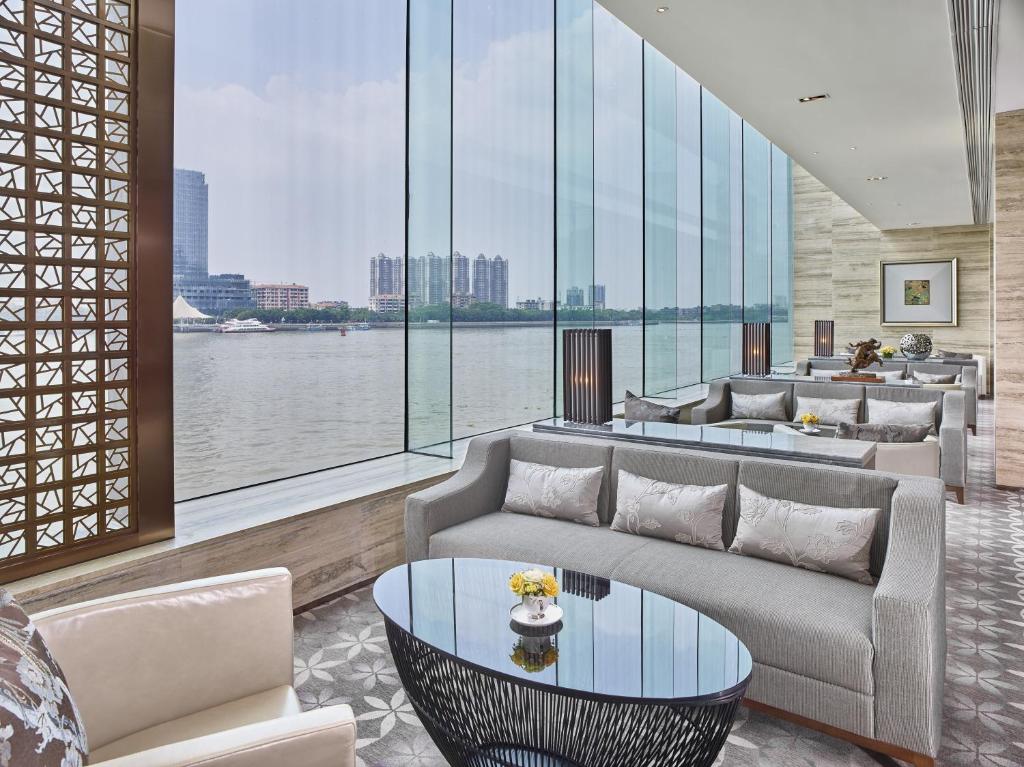 a living room with couches and a view of the water at White Swan Hotel in Guangzhou