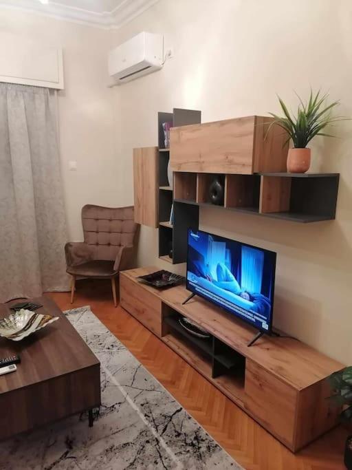 a living room with a television on a wooden entertainment center at Filoxenia.kom in Athens