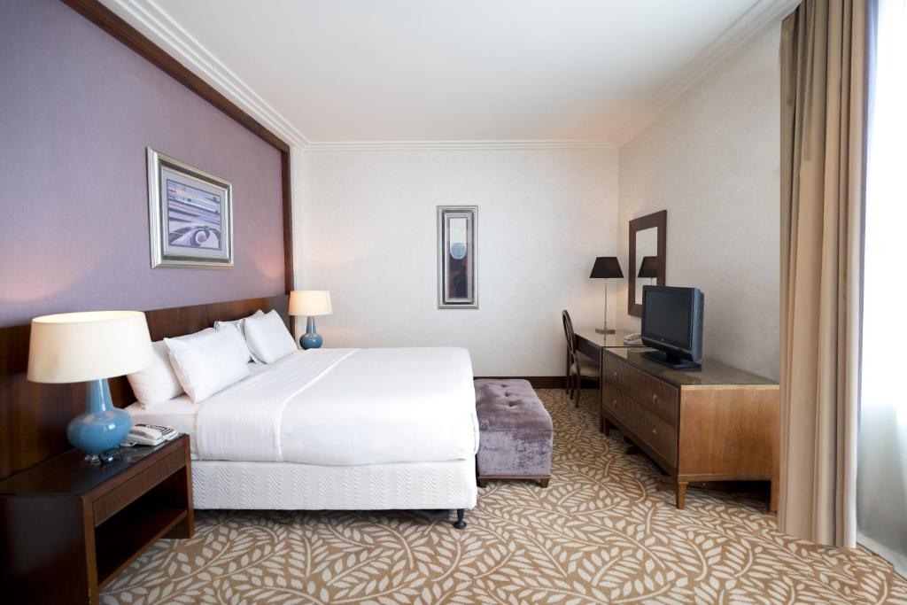 a hotel room with a bed and a television at SAJA Hotels Makkah in Al Masfalah