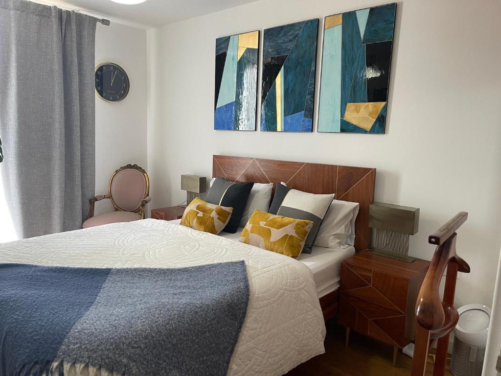Un dormitorio con una cama y cuadros en la pared. en Peloton Organic Health Apartment in Angel, Old Street, Islington, en Londres