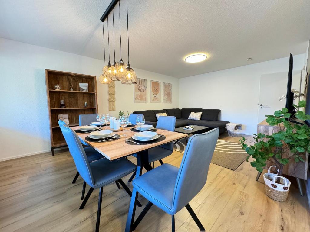 een eetkamer met een tafel en blauwe stoelen bij 3 Zimmer Apartment, 90 qm, ruhig und zentrumsnah, max 6 Pers, 15 qm Balkon , private Garage, Internet 1000 MBit in Sindelfingen