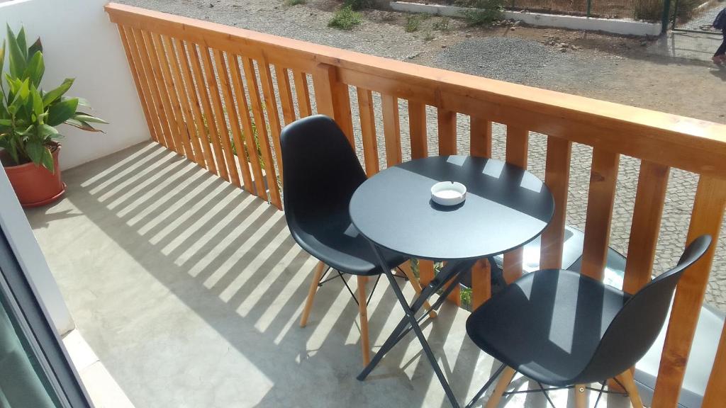 einen Tisch und zwei Stühle auf dem Balkon in der Unterkunft Apartamentos Santiago - Tarrafal in Tarrafal