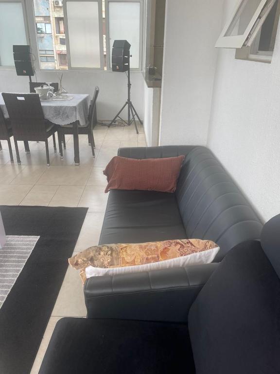 ein Wohnzimmer mit einem Sofa und einem Tisch in der Unterkunft Sunny Luanda in Luanda