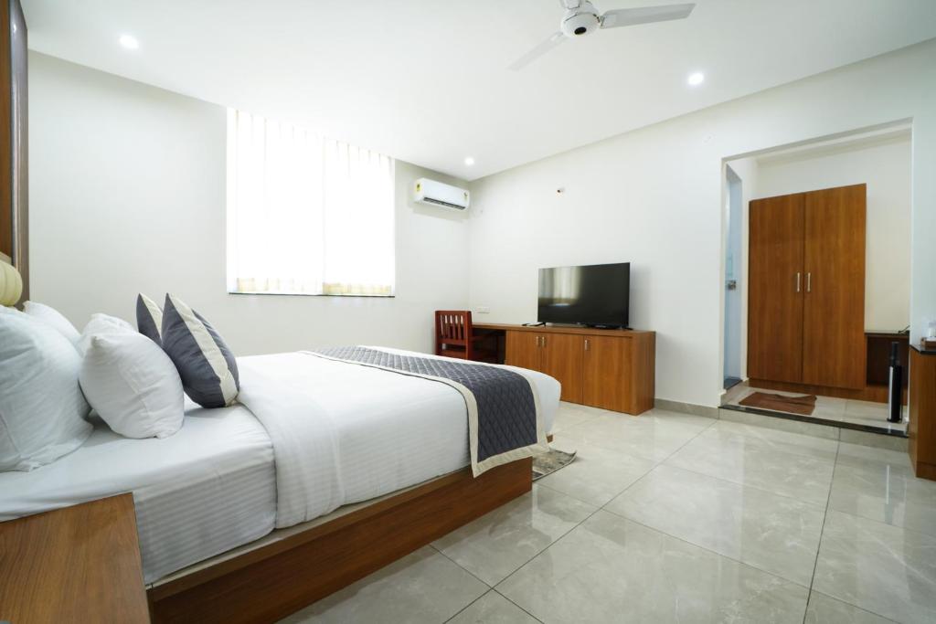 a bedroom with a large bed and a television at RC Comforts in Chikmagalūr