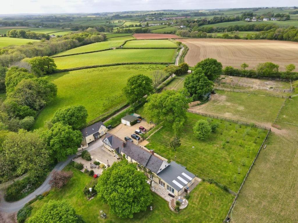 an aerial view of a house in a field at Pheasants Roost With Indoor Pool In Devon in Broadwoodkelly