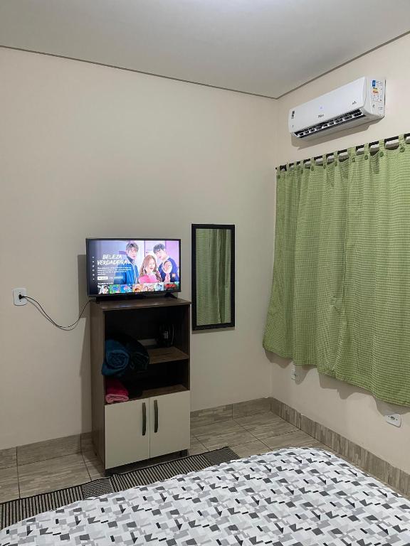 a bedroom with a flat screen tv on a stand at Apartamento próximo ao centro in Primavera do Leste