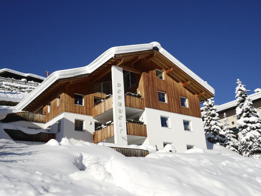 um edifício coberto de neve com neve à sua volta em Haus Bergwelt - Appartements em Lech am Arlberg