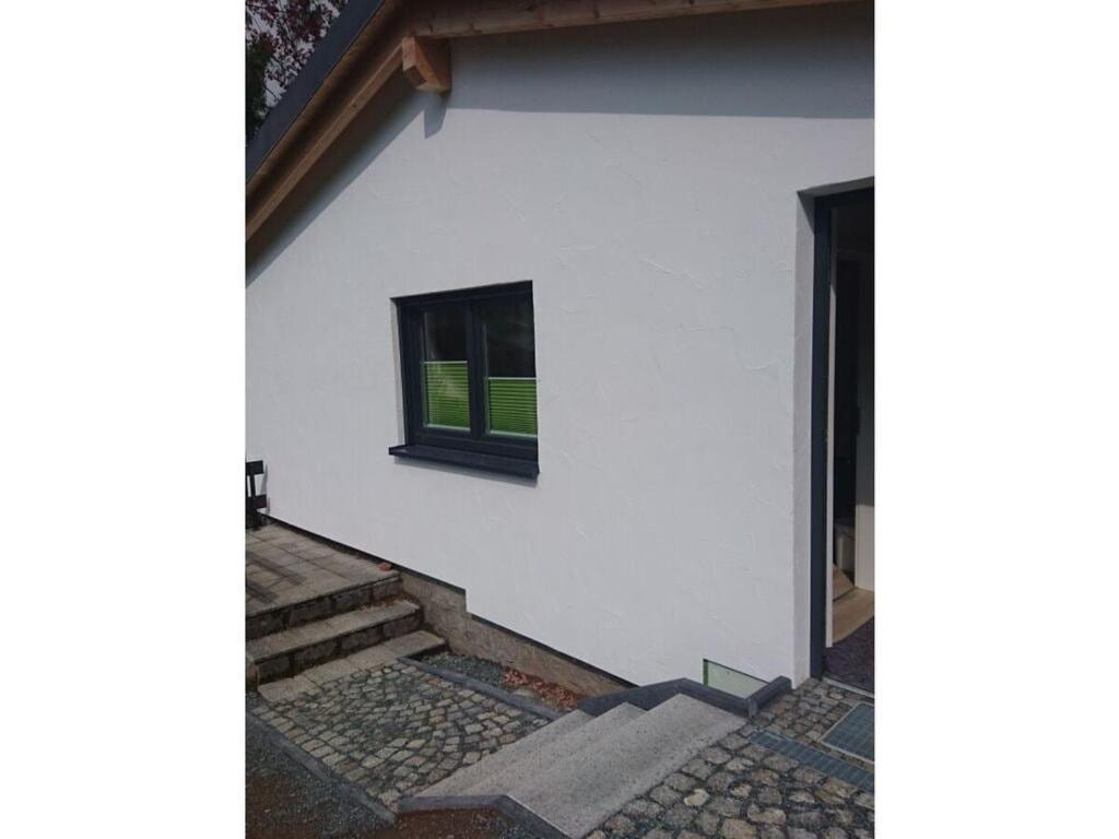Casa blanca con ventana y escaleras en Holiday home Am Dachsberg, en Burkhardtsdorf