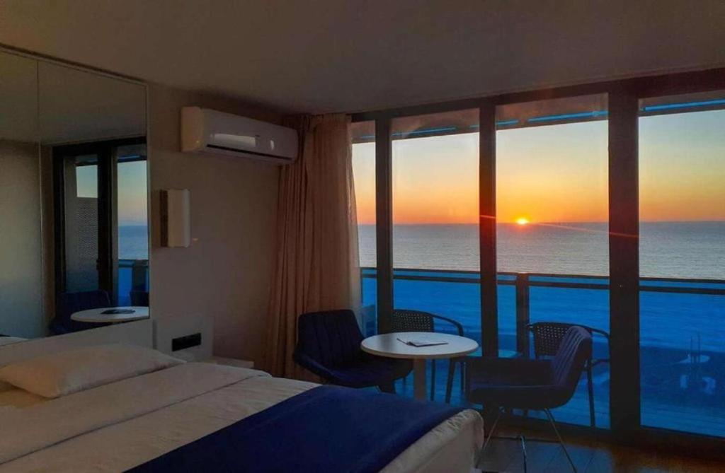 a hotel room with a bed and a view of the ocean at Holiday in orbi city in Batumi