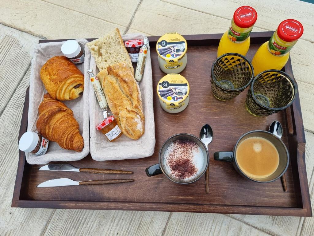 a tray with bread and pastries and a cup of coffee at Le Cocoon in Carpentras