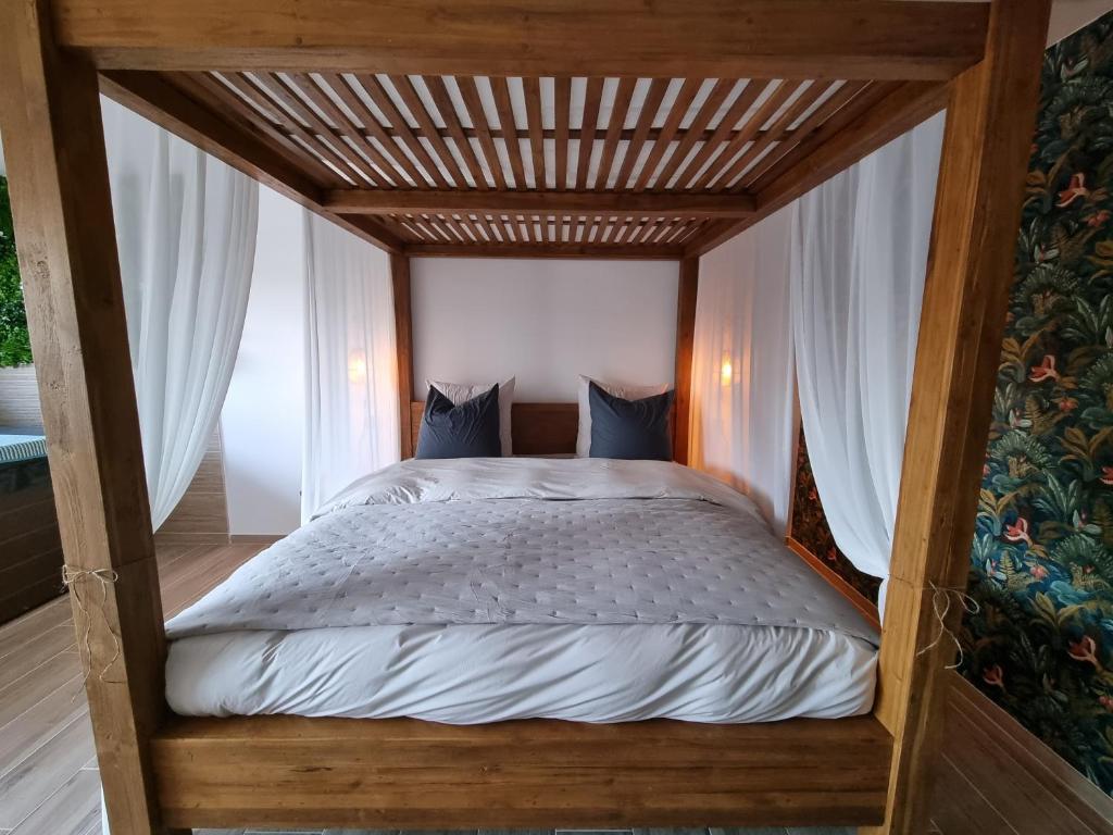 a bed with a wooden canopy in a bedroom at Le Cocoon in Carpentras