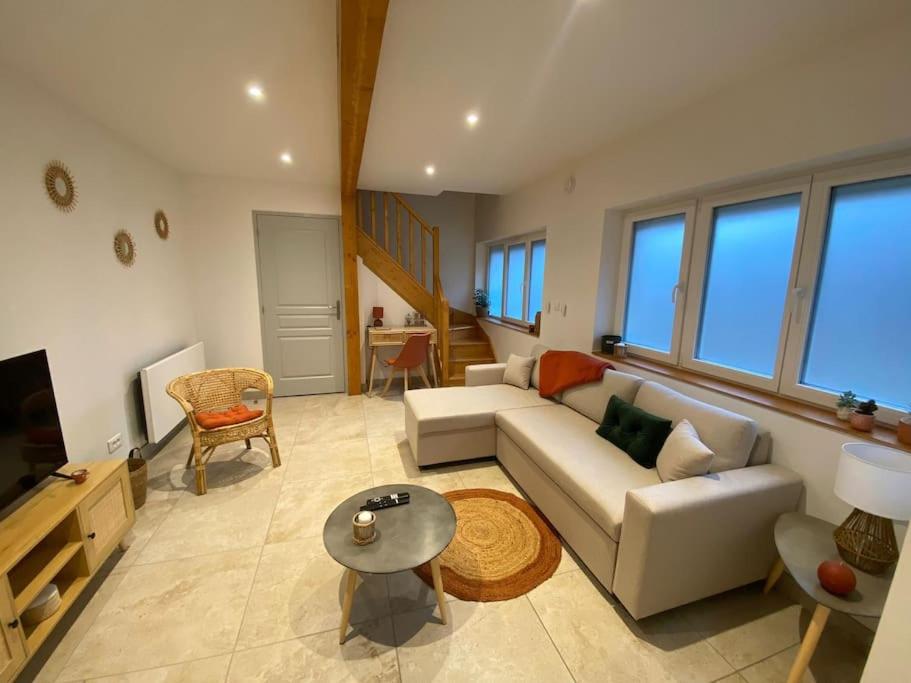 ein Wohnzimmer mit einem Sofa und einem TV in der Unterkunft La Petite Maison du Canal in Digoin