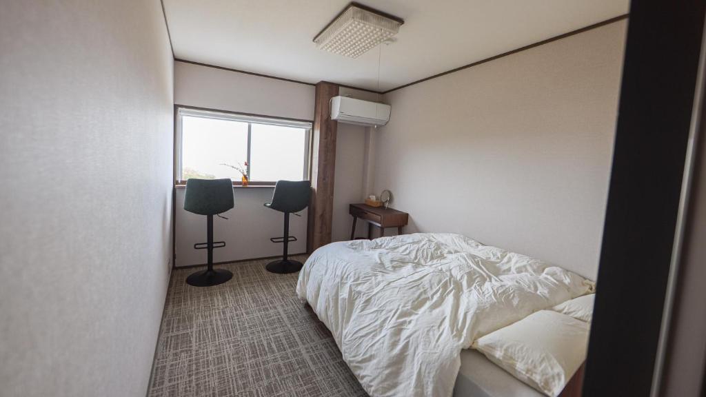 a bedroom with a white bed and a window at Tainan House台南家 in Awaji